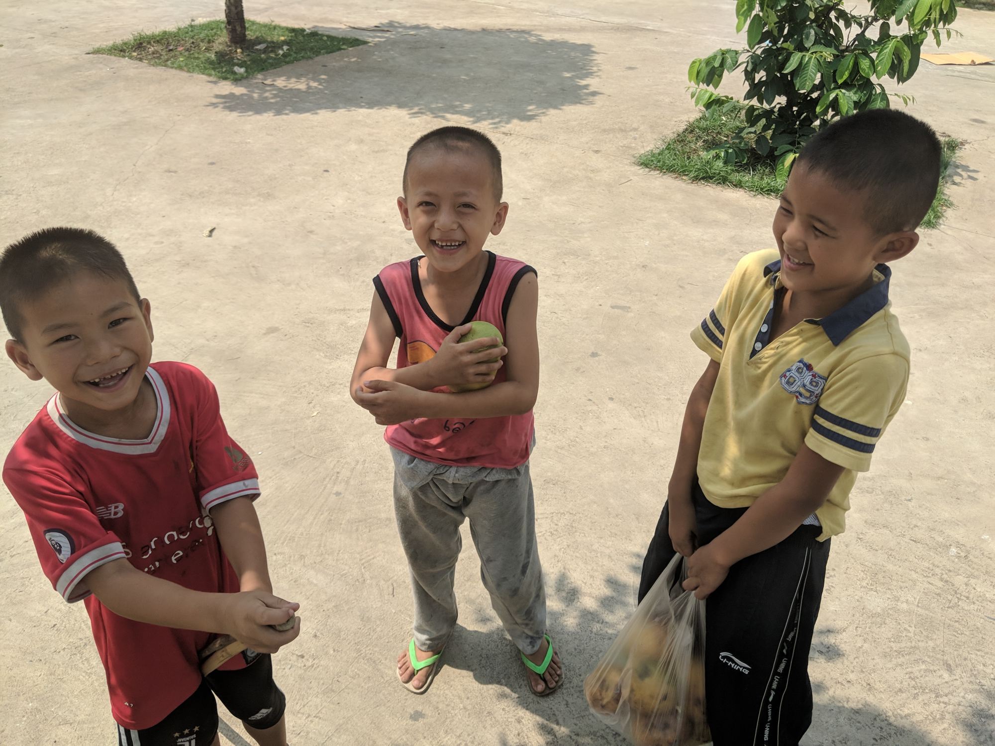 Three young boys laughing together at Wat Don Chan Orphanage in Thailand