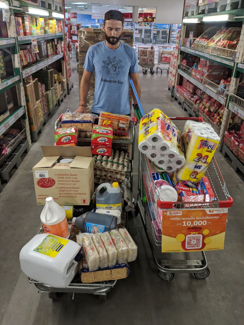 Two shopping carts loaded with food, eggs, rice and household supplies